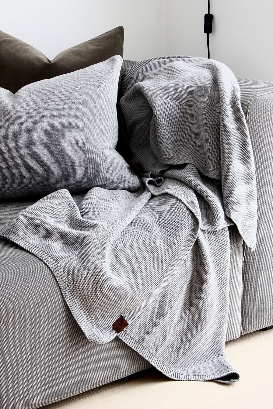 Strikket Plaid-By Lohn-Medium Grey Melange-Vist på sofa med pude